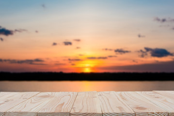 Empty wooden board table top on of blurred sunset and lake background. with copy space for display or montage your products