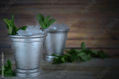 Cuadros en Lienzo Image for Kentucky Derby in May showing two silver mint julep cups with crushed ice and fresh mint in a rustic setting
