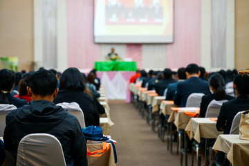 Rear view soft focus photo of people participating conference listening to the speaker in conference room