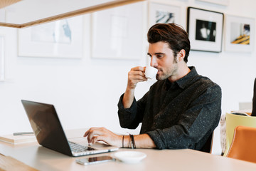 Wall Mural - Casual man working in a cafe