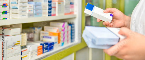 Cuadros en Lienzo Pharmacist holding medicine box in pharmacy drugstore.