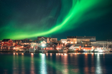 Wall Mural - Northern lights over fishing village on coastline at Lofoten