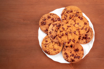 Wall Mural - Chocolate chip cookies, shot from the top on a dark rustic wooden background with a place for text