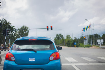 car driving stopped on crossroad with red traffic light