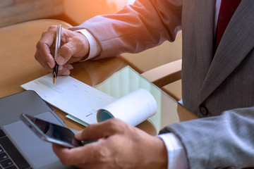 Wall Mural - Business work on computer and mobile phone., sign cheque at office.