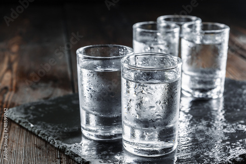 Fotomural Vodka in shot glasses on rustic wood background