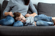 © Aliaksandr Marko - The boy is lying on the couch with an abdominal pain near his mother. The concept of custody, parental care, stomach problems, food poisoning, problems in children.