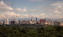Unfiltered Realistic Aerial Sky View Of Kuala Lumpur Skyline Buildings At A Distance, With Trees And Nature