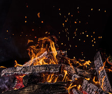 Flaming Logs, Fire Flames With Sparks Flying In The Air, Close-up.