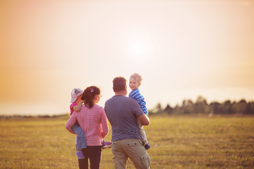 Wall Mural - girl with mother and father holding hands on the nature