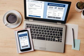 Wall Mural - boarding pass concept on laptop and smartphone screen