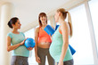 © Syda Productions - pregnancy, fitness and healthy lifestyle concept - group of happy pregnant women with sports equipment talking in gym