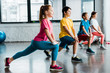 Group of cheerful kids doing stretching in gym