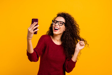 Portrait of her she nice cute attractive pretty winsome cheerful wavy-haired lady holding in hands cell reading funny notification isolated on bright vivid shine orange background