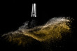canvas print picture - Cosmetic brush with golden cosmetic powder spreading for makeup artist and graphic design in black background