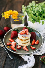 Delicious Soft Pancakes With Fresh Strawberries Placed On Ceramic Plate Near Potted Plant And Glass With Yellow Flower
