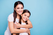 © deagreez - Close up photo pretty two people brown haired mum small little daughter best friends stand hugging piggy back lovely nice free time rejoice wearing white t-shirts isolated on bright blue background