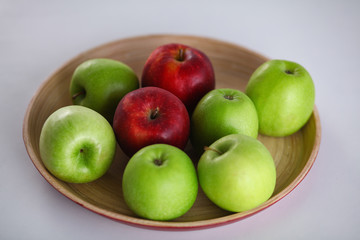 Wall Mural - Green and red apple lies on a white table