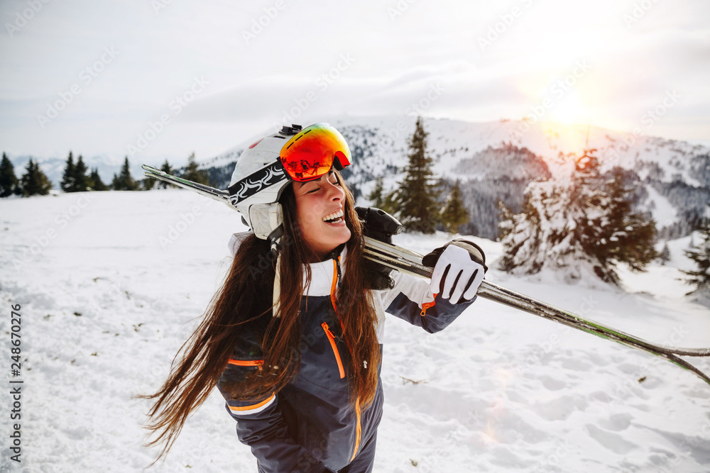 Portrait of beautiful woman with ski and ski suit in winter mountain - obrazy, fototapety, plakaty 