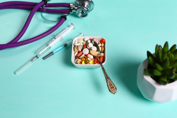 Sticker - Medical syringe, pill, stethoscope and flask on a blue background closeup