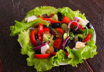 salad from fresh vegetables in a plate on a table, selective focus