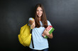 © 5second - Young girl with backpack and books on blackboard background