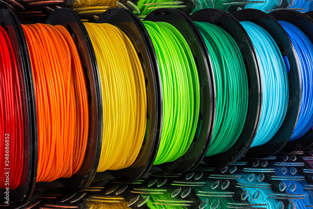 colorful bright  row of spool 3d printer filament black metal background - obrazy, fototapety, plakaty 