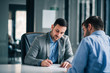 © bnenin - Two business men on meeting in the office, signing contract.