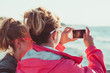 © Przemek Klos - Mother and her daughter taking a photos over sea during summer vacation using smart phone camera