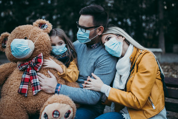  Young family in protective mask outdoors in park. Air pollution concept.