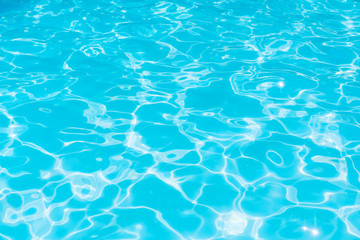 Blue water in pool for background and abstract, Ripple wave with sun reflection in swimming pool, Clean and bright purified water for healthy swimming