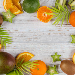 Wall Mural - Green palm leaves and fresh tropical slices of fruits