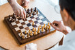 © LIGHTFIELD STUDIOS - selective focus of wooden chess board with retired men playing chess at home