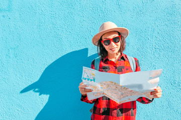 Wall Mural - a young happy asian girl in a hat travels with a map in Burano, Venice