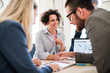 © Halfpoint - Group of young businesspeople with laptop working together in a modern office.
