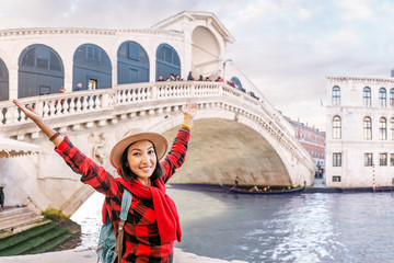 Wall Mural - Happy asian woman admiring great view of the famous bridge over Grand Canal in Venice, vacation and travel in Italy concept