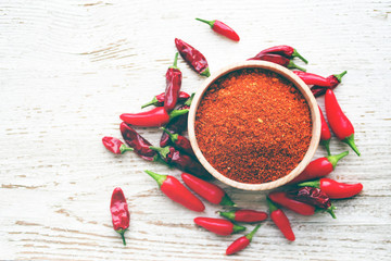 Red chili pepper and spices in wooden bowl on wooden old background