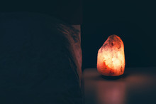 Himalayan Salt Lamp Glowing On Dark Background With Space For Text
