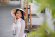 © gorynvd - Close up portrait of pretty asian girl dressed in Ao Dai dress wearing vietnamese conical hat.