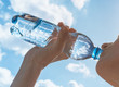 © kieferpix - Female drinking bottle of water on a hot summer day.