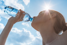 Female Drinking Bottle Of Water On A Hot Summer Day.