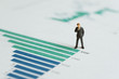 © Nuthawut - Miniature businessman leader standing with bar graph and chart of company annual report with vision of year 2019 revenue growth in green bar, forecast of company profit and stock investment concept