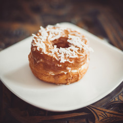 coconut maple cronut on a white plate.