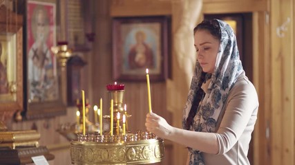 Wall Mural - lifestyle woman praying in Church in front of icons, Russian Orthodox wooden Church, view inside