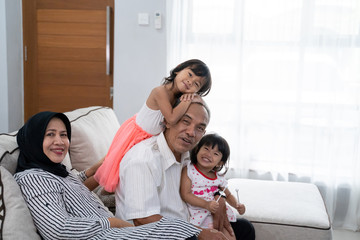 grandparent and granddaughter having fun playing around at home in living room