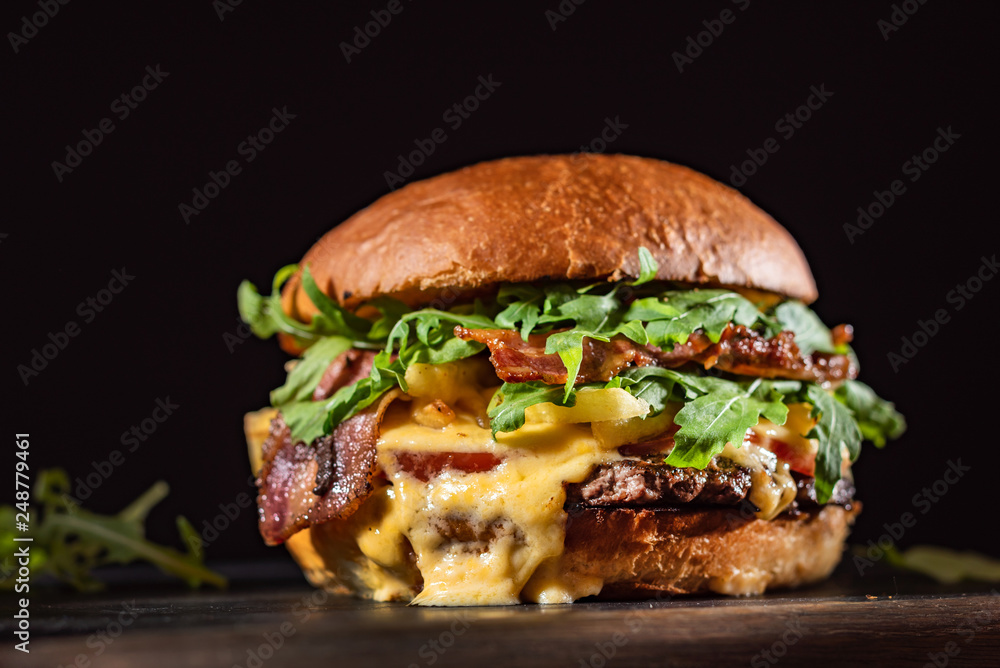 Homemade beef burger with crispy bacon and vegetables on rustic serving board - obrazy, fototapety, plakaty 