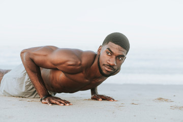 Wall Mural - Fit man doing pushups in the sand