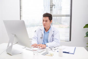 Wall Mural - Portrait of senior doctor sitting in medical office