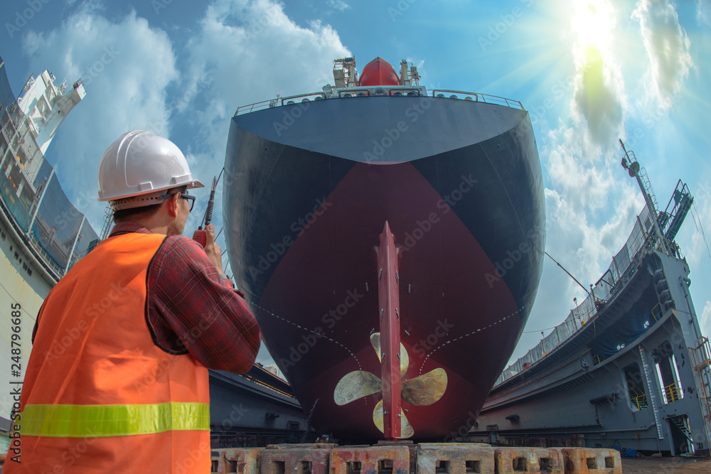 supervisor, foreman, inspector, surveyor takes final inspection of the cleaning, repairing, recondition of over hull of the commercial ship in dry dock yard, ready to delivery the ship to the sea - obrazy, fototapety, plakaty 