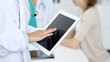 © rogerphoto - Doctor woman using tablet computer, close-up of hands at touch pad screen. Medicine and data concepts